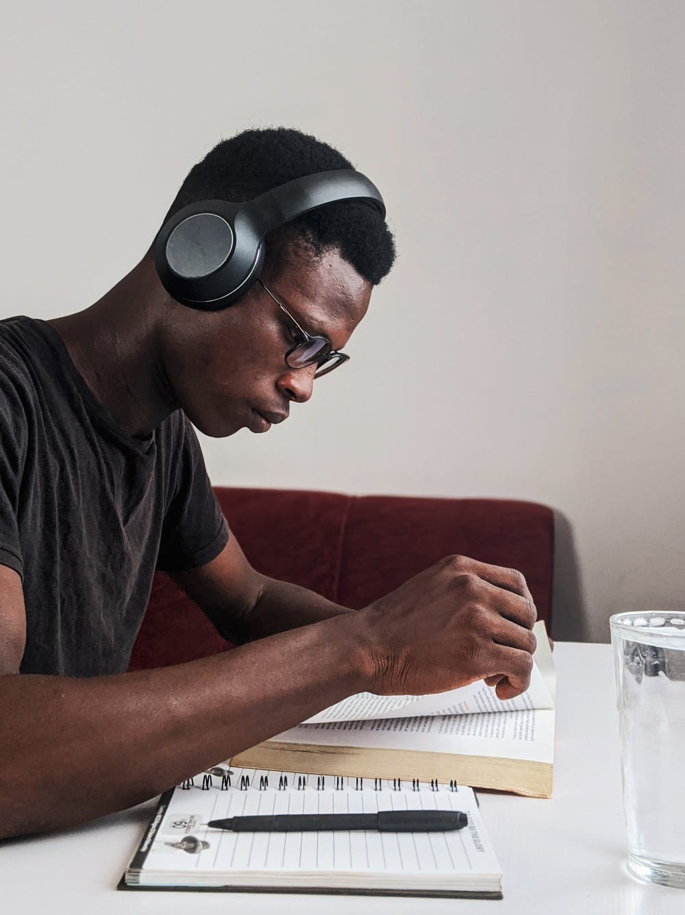 Student wearing headphones reading a book